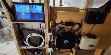 Home surveillance and networking setup with monitors and routers.