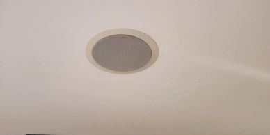 Ceiling speaker mounted on a white ceiling.