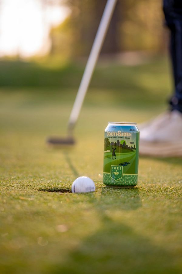 A golf ball and a can of Southside soda on a golf course green.