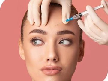 Woman receiving a cosmetic injection in her forehead.