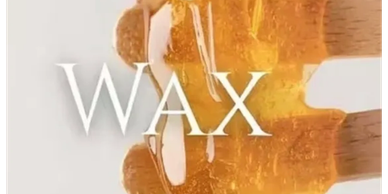 Close-up of dripping honey with the word 'WAX' overlayed.