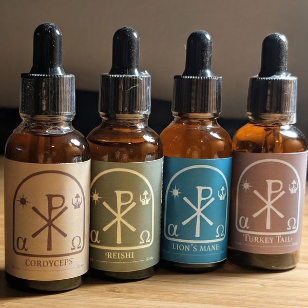 Four dropper bottles of medicinal mushroom extracts.