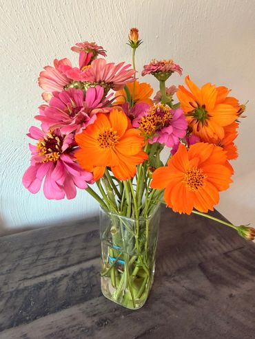 Colorful bouquet of pink and orange flowers in a glass vase.