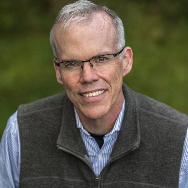 White man with glasses and gray hair smiling