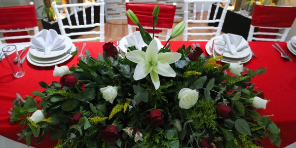 Elegant dining table with red roses and white lilies centerpiece.
