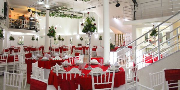 Elegant banquet hall with red and white decor and floral centerpieces.