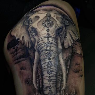 Detailed black and gray elephant tattoo with ornamental designs on the head.