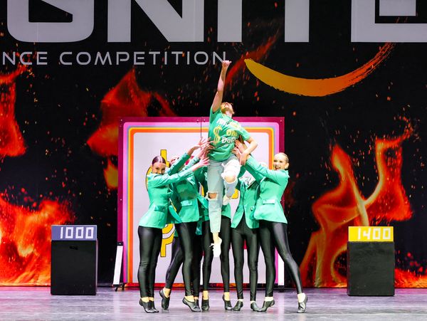 A group of dancers in green shirts in a "Price is Right" themed production number