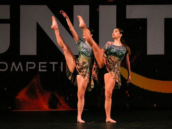Duet dancers in multicolored costumes onstage