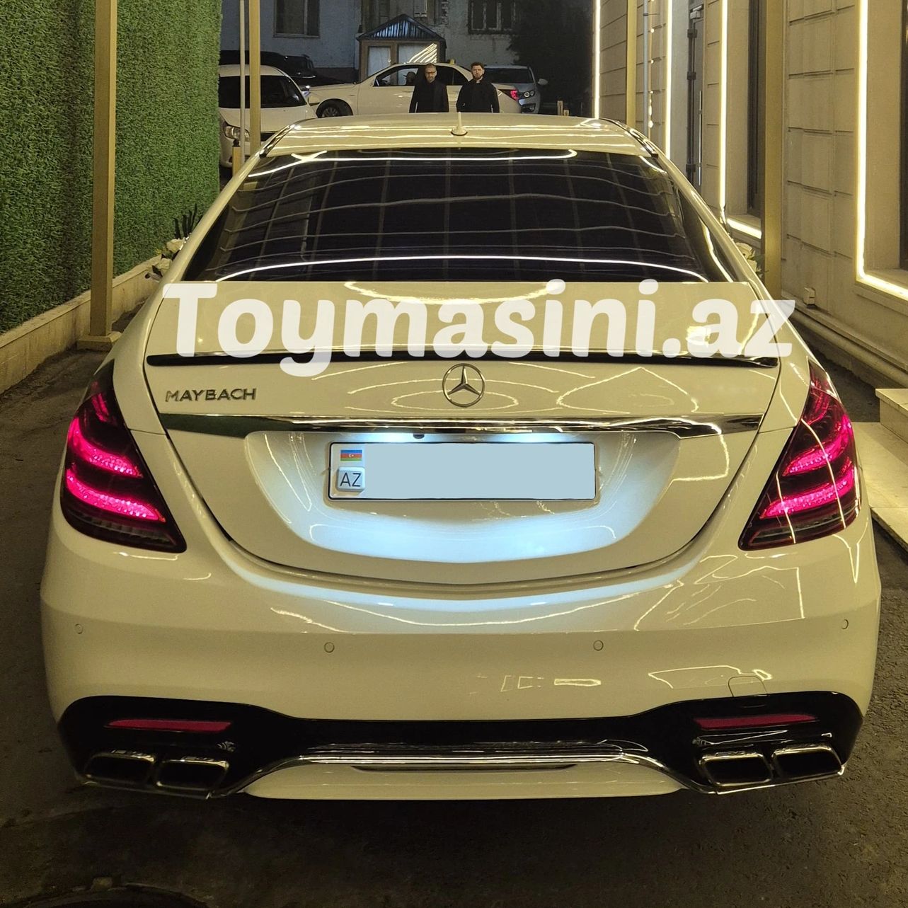 Rear view of a white Mercedes-Maybach car at night.