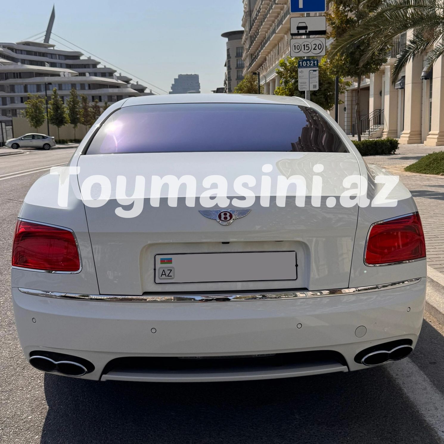 Rear view of a white Bentley car parked on a city street.