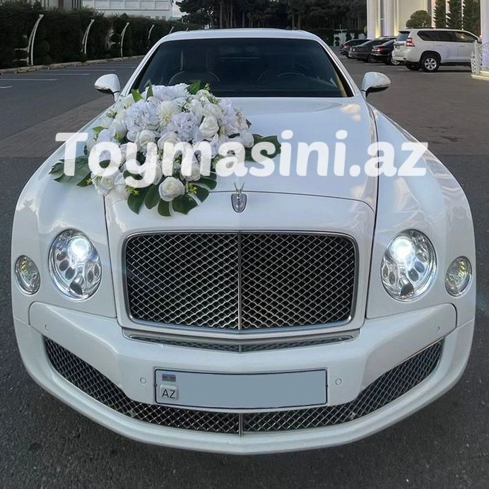 White luxury car decorated with white flowers on the hood.
