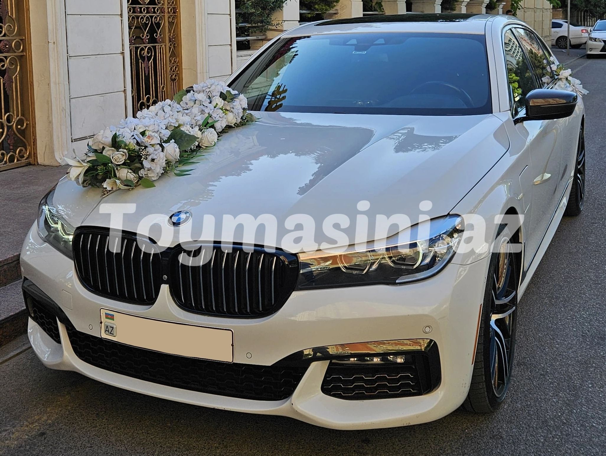 Beyaz BMW düğün arabası çiçek süslemeleriyle.