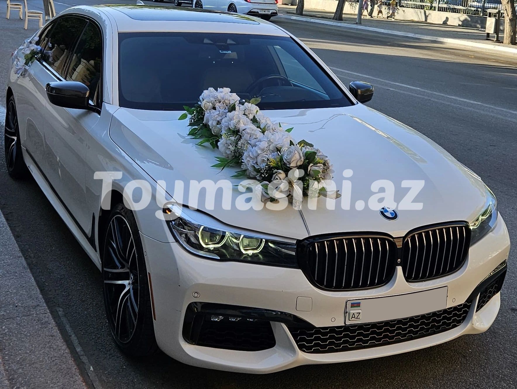 Çiçek süslemeli beyaz BMW düğün arabası.