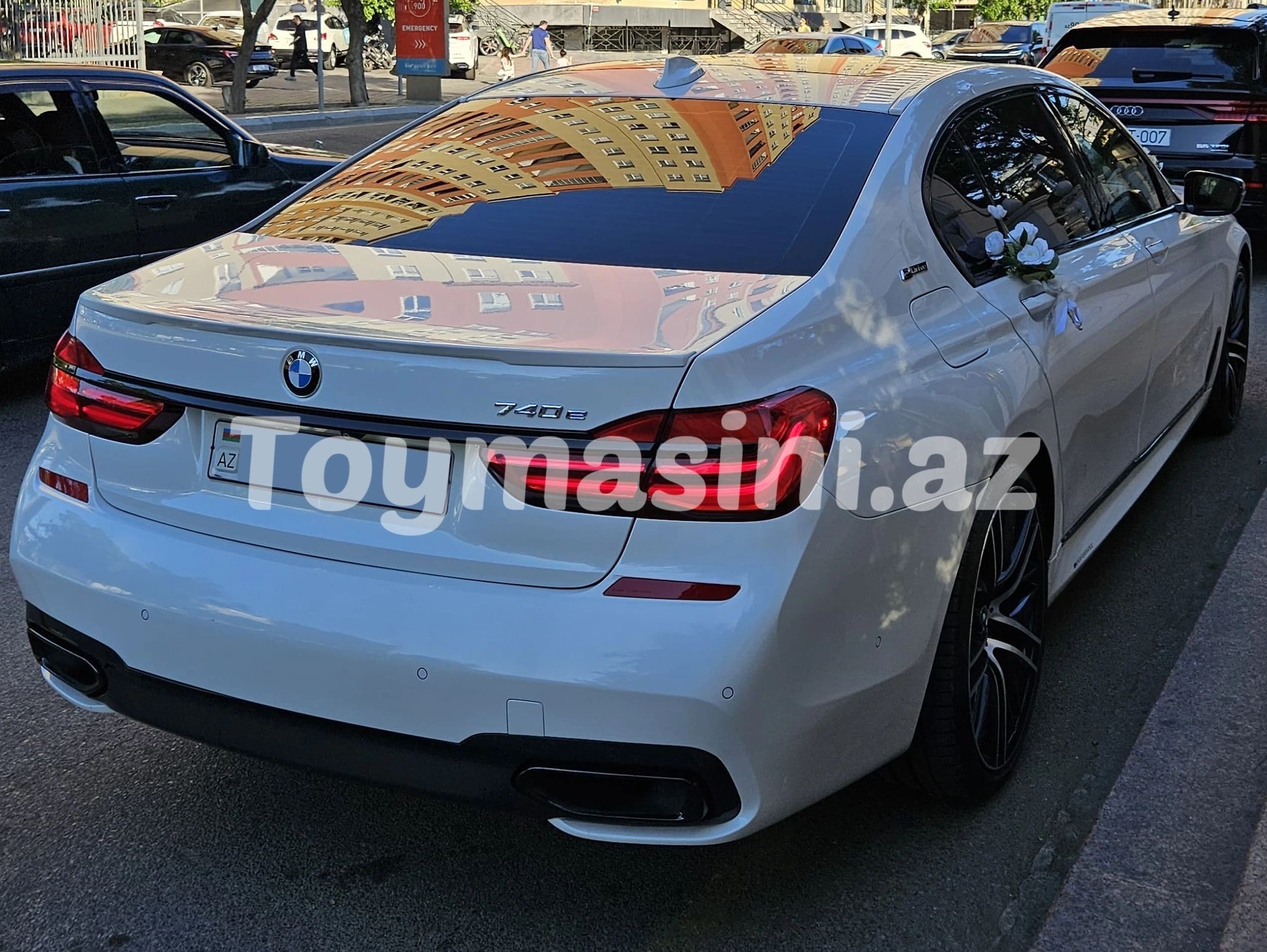 Beyaz BMW 740e model araç, yan kapısında çiçeklerle süslenmiş.