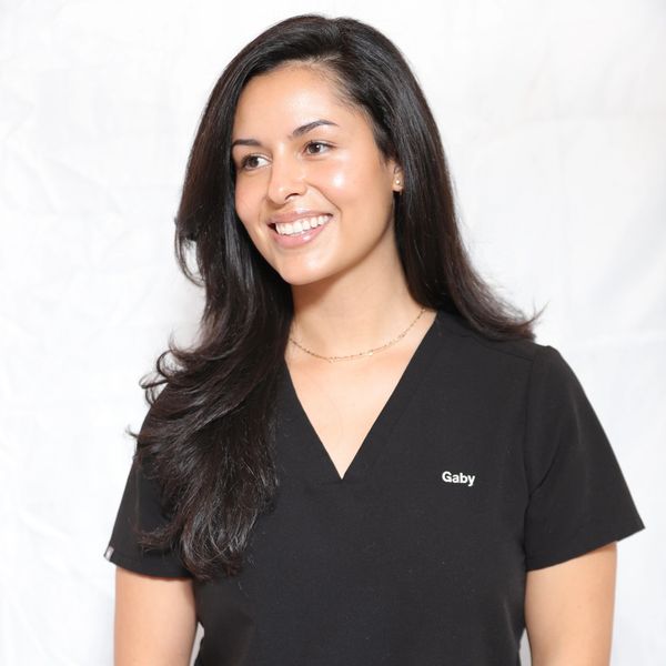 Smiling woman with long dark hair wearing a black shirt named Gaby.