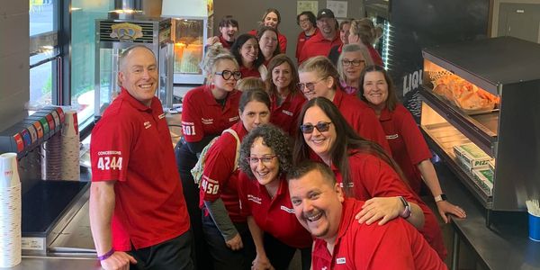 Team working at the concert in red shirts
