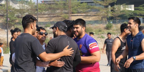 Group of friends greeting and smiling outdoors on a sunny day.