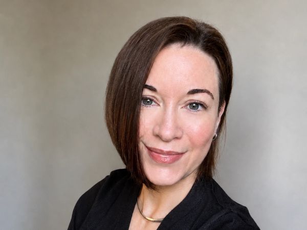 Woman with straight brown hair smiling at the camera.