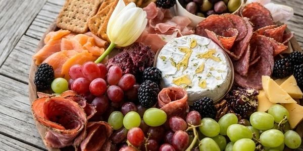 A vibrant charcuterie board with meats, cheeses, fruits, and crackers.