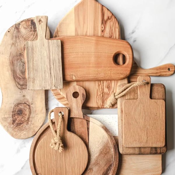 A collection of assorted wooden cutting boards on a marble surface.