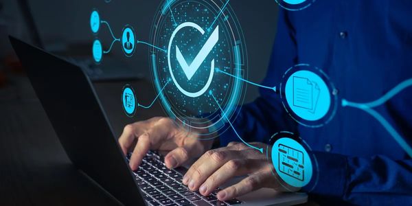 Person using laptop with digital checkmark and icons overlay.