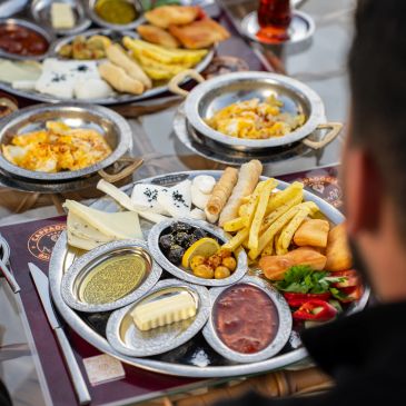 Zengin kahvaltı tabağı ve bir kişi.