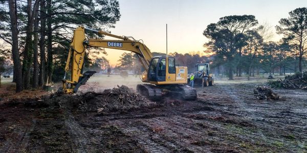 Excavator Uprooting Trees on Land in Countryside