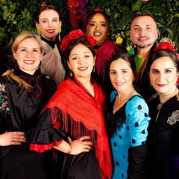Group of flamenco dancers in costume smiling. 
Photo by @triciclestudio