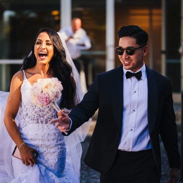 Happy bride and groom walking together outdoors after their wedding.