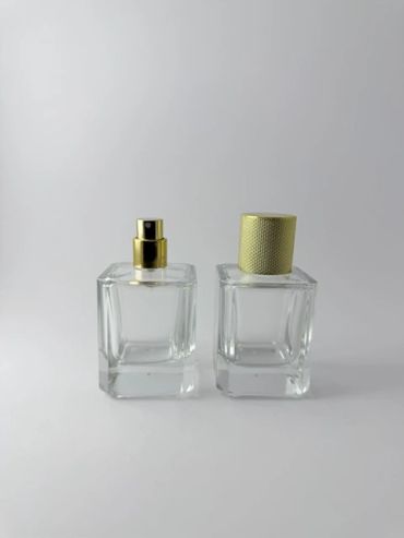 Dos botellas de perfume con tapa dorada.