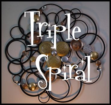 Decorative wall art named 'Triple Spiral' with circular metal and textured discs.