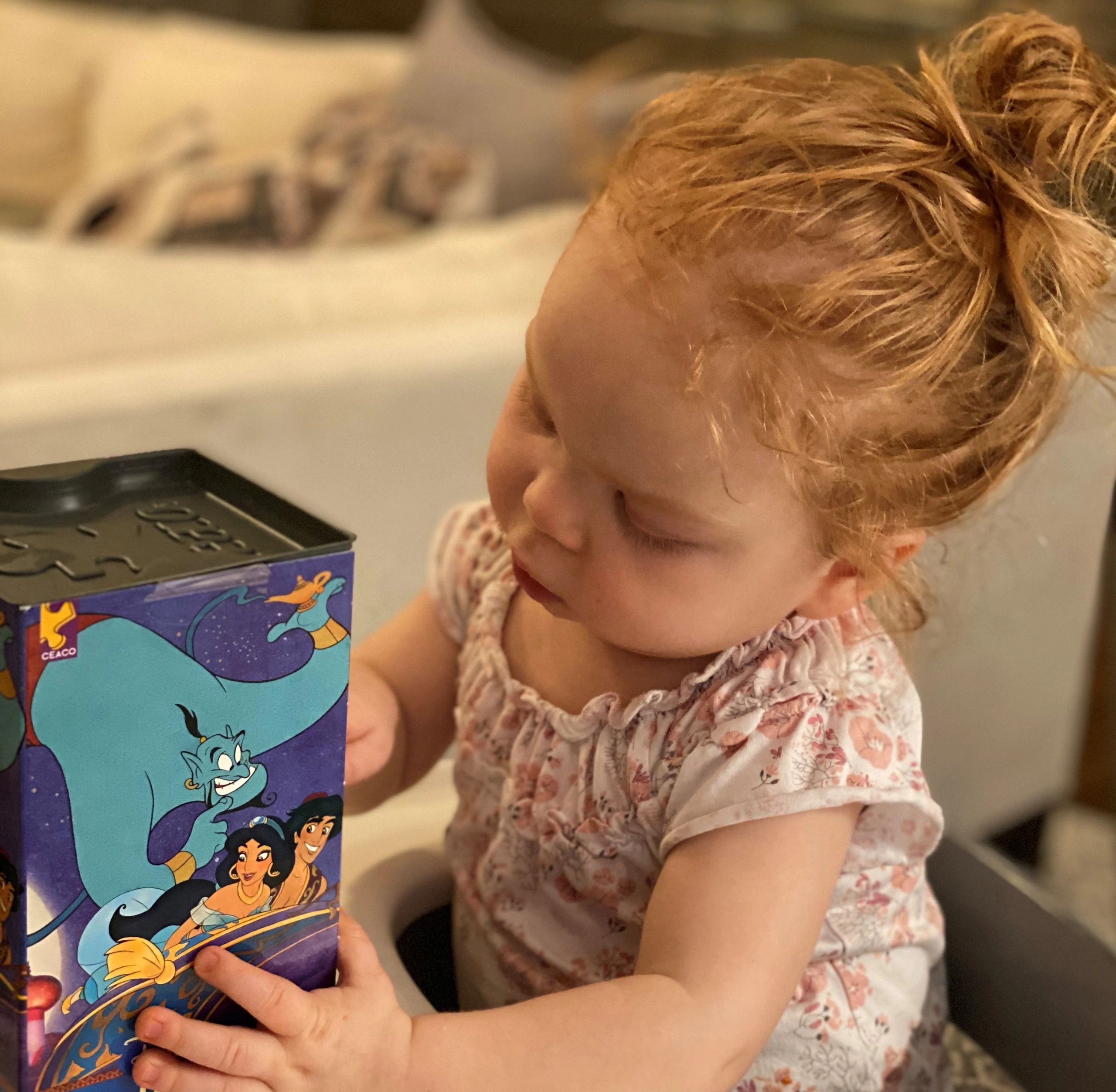 Developmentally delayed, genetically rare, undiagnosed child looking at Aladdin puzzle 