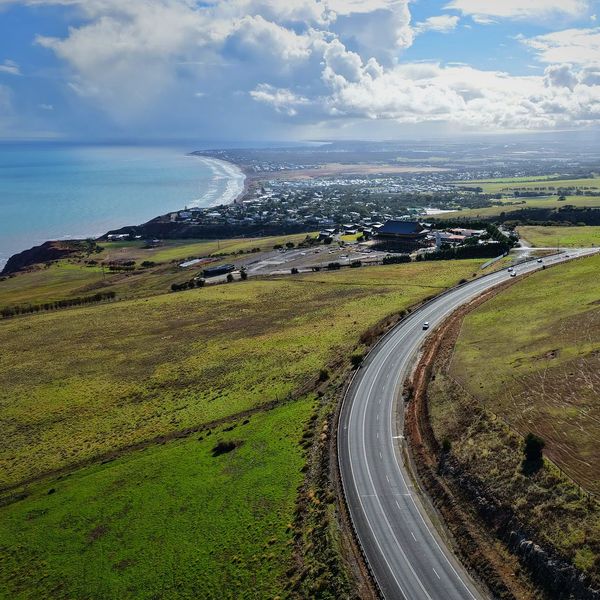 Winding road leading to coastal towns with rolling green hills and ocean