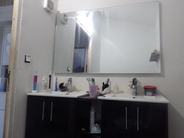 Lavabo double avec miroir et accessoires de salle de bain.