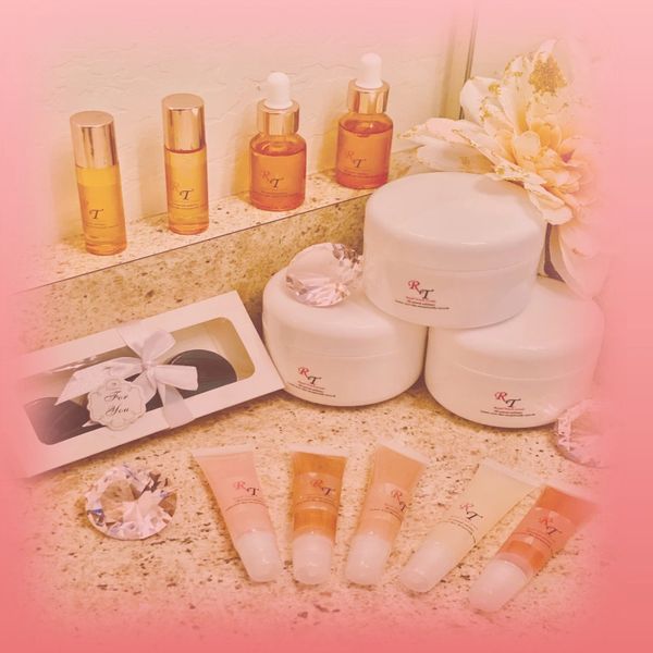 Elegant skincare products arranged on a countertop with a soft pink gradient background.