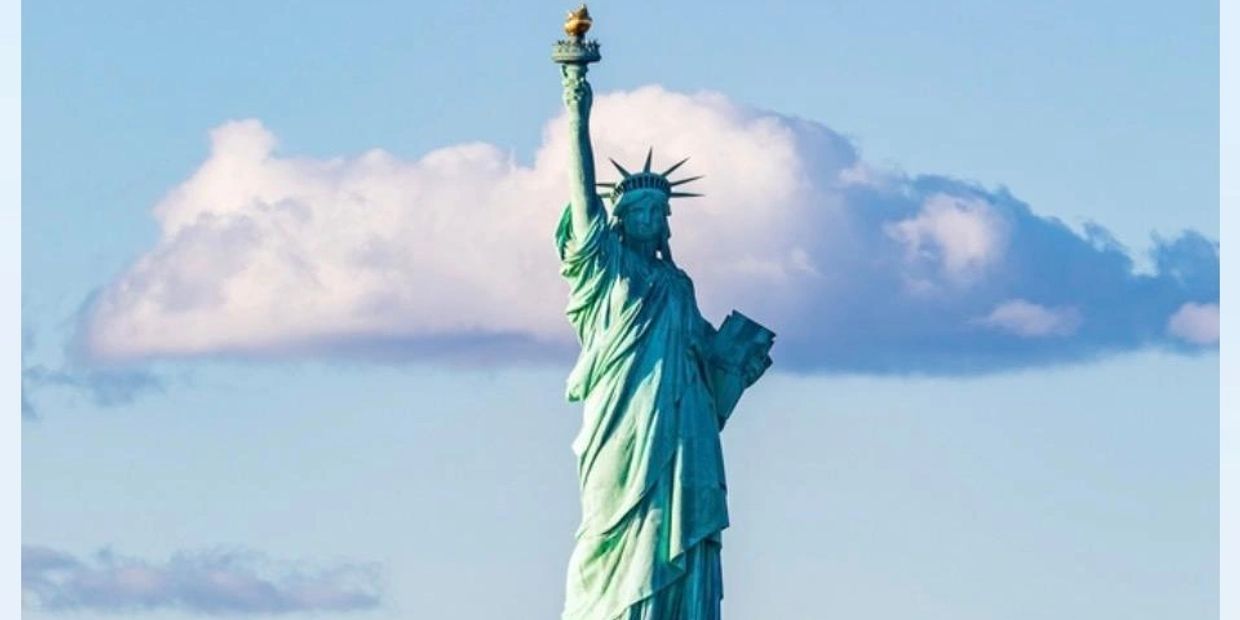 Statue of Liberty with a cloud behind it.