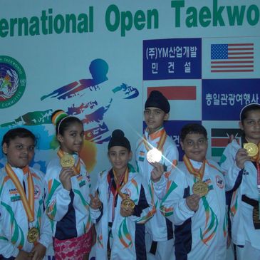 Young Taekwondo athletes from India proudly display their gold medals.