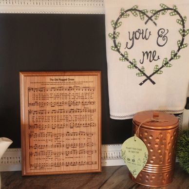 Framed sheet music and a towel with "you &amp; me" on a kitchen shelf.