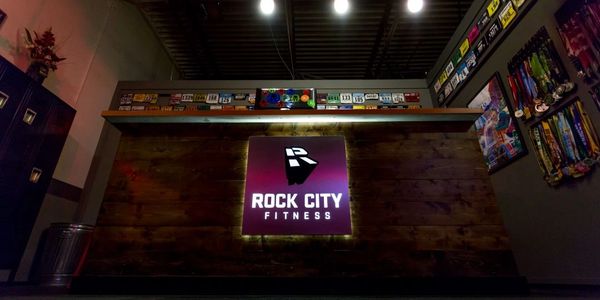 Rock City Fitness front desk with racing bibs and medals.