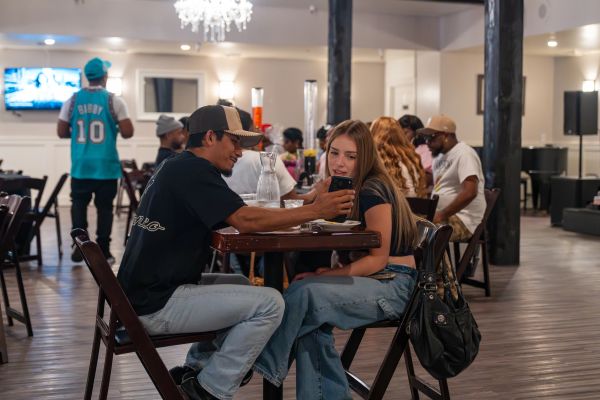 A couple sharing a moment at a table in a cozy, modern lounge.