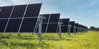 A field of solar panels under a blue sky.