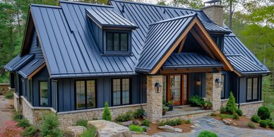 Modern house with a sleek metal roof and stone exterior.