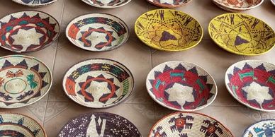 Colorful handmade woven baskets arranged on a table.