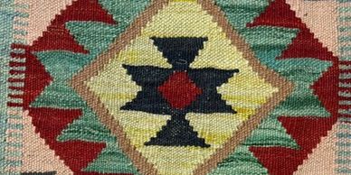 Close-up of a colorful woven textile with geometric patterns.
