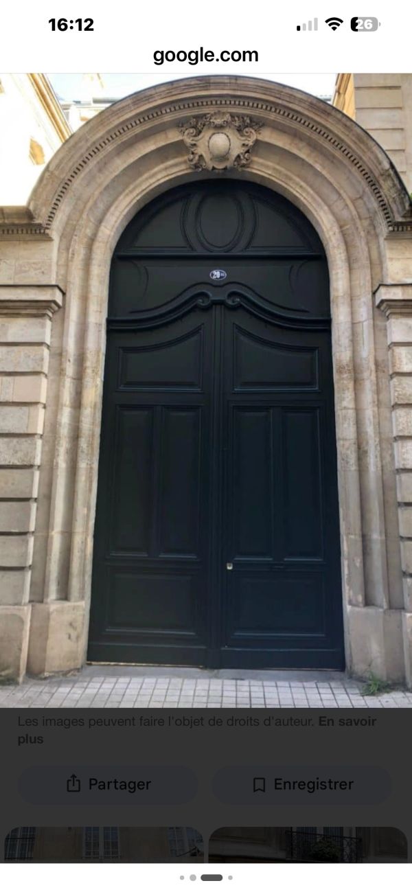 Elegant black arched door with intricate stone frame in classic architecture.