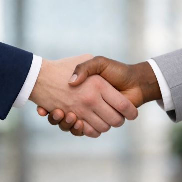 Two business professionals shaking hands in agreement.