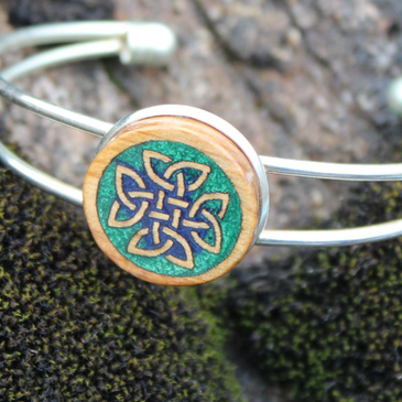 Close-up of a silver bracelet with a wooden Celtic knot design.