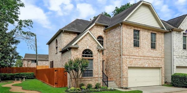 Brick two-story house with a well-kept lawn.