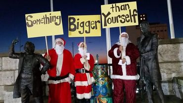 three people in Santa costume